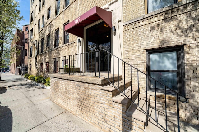 doorway to property featuring brick siding