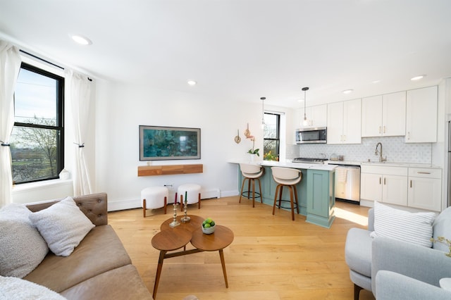 living area with light wood finished floors, recessed lighting, and baseboards