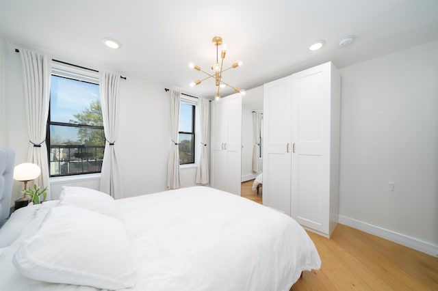 bedroom featuring light wood-style flooring, recessed lighting, a notable chandelier, and baseboards