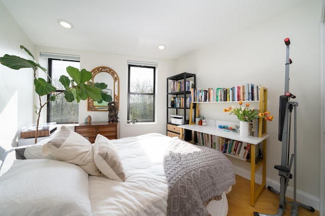 bedroom with recessed lighting, wood finished floors, and baseboards