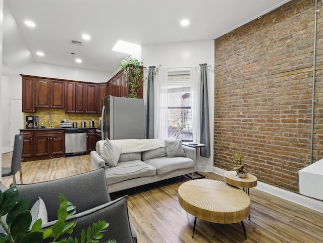 77 Crescent Ave Unit 8, Jersey City, NJ 07304 - living area with brick wall, light wood-style flooring, baseboards, and recessed lighting