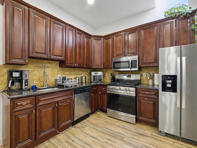 77 Crescent Ave Unit 8, Jersey City, NJ 07304 - kitchen with appliances with stainless steel finishes, a sink, light wood-style flooring, tasteful backsplash, and dark stone countertops