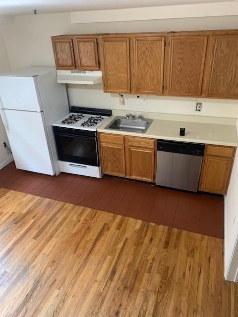 kitchen featuring sink, dark wood-type flooring, and white appliances