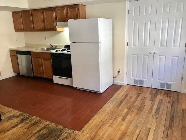 kitchen featuring sink, dark wood-type flooring, and white appliances