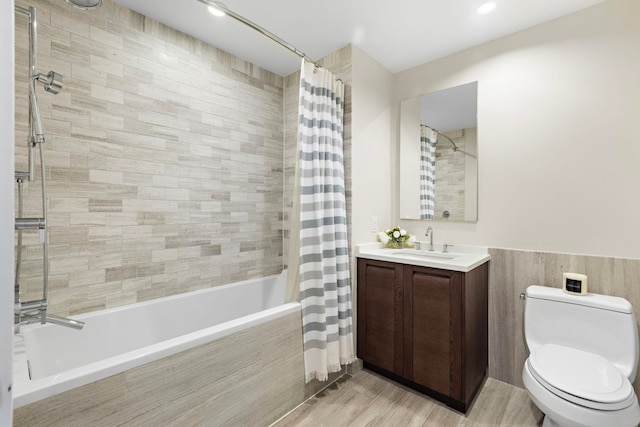 bathroom with tiled shower / bath, toilet, wood finished floors, and vanity