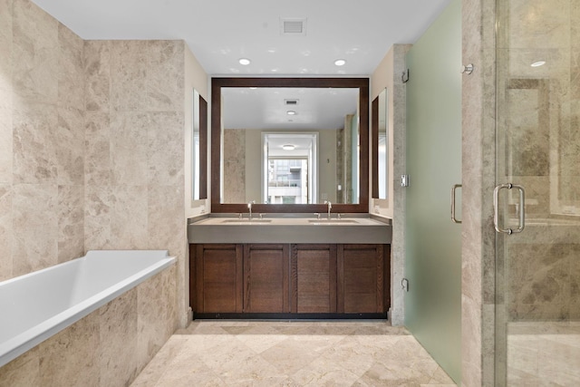 bathroom with tiled bath, visible vents, a shower stall, double vanity, and a sink