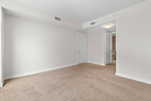 carpeted empty room with baseboards and visible vents