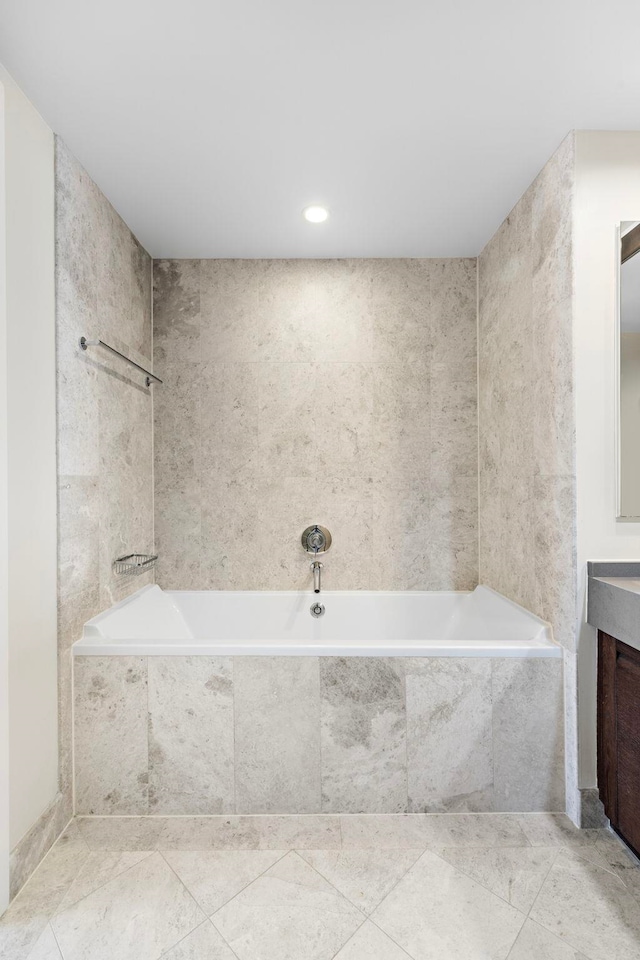 bathroom with vanity and a relaxing tiled tub