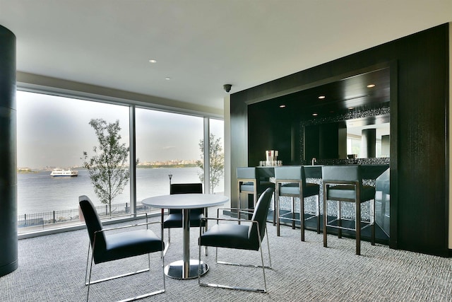 dining space with a water view and carpet floors