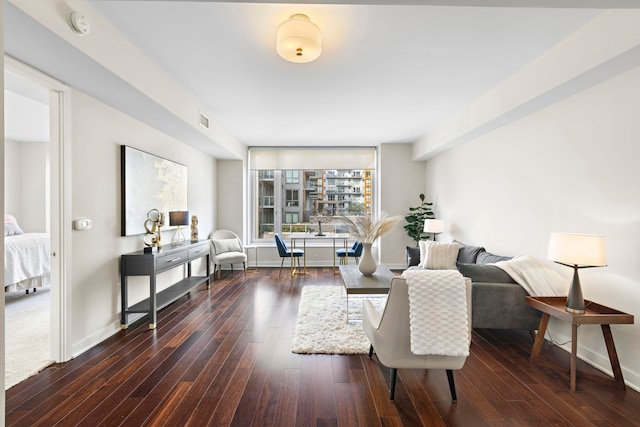 living area featuring visible vents, baseboards, and dark wood finished floors