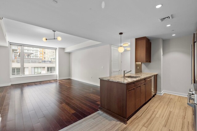 kitchen with a sink, light wood-style floors, a peninsula, and recessed lighting