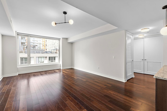 interior space featuring dark wood-type flooring, visible vents, and baseboards