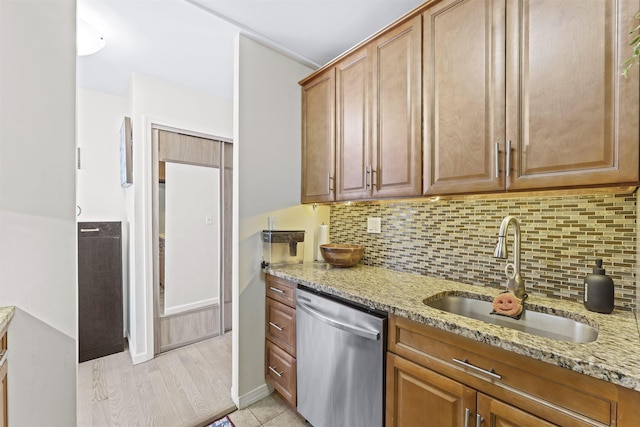 100 Manhattan Ave Unit 1217, Union City, NJ 07087 - kitchen with stainless steel dishwasher, a sink, light stone countertops, decorative backsplash, and brown cabinetry