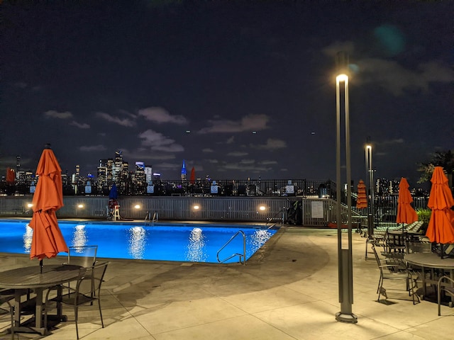 100 Manhattan Ave Unit 1217, Union City, NJ 07087 - pool at night with fence, a community pool, and a patio