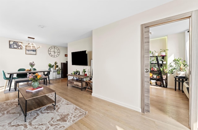 100 Manhattan Ave Unit 1217, Union City, NJ 07087 - living room featuring a chandelier, light wood-type flooring, and baseboards