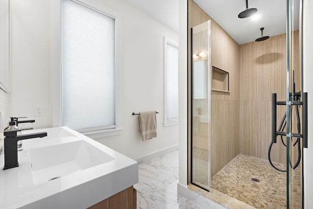 bathroom featuring baseboards, marble finish floor, and a tile shower