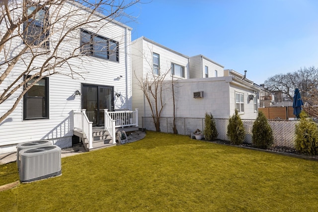 back of property featuring cooling unit, a lawn, and fence