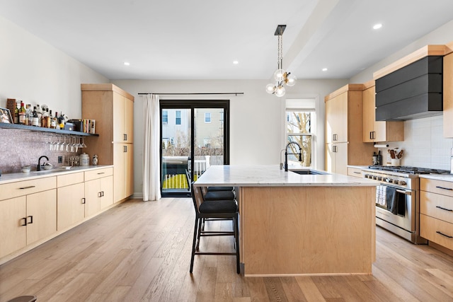 kitchen featuring a sink, high end stainless steel range oven, and light brown cabinets