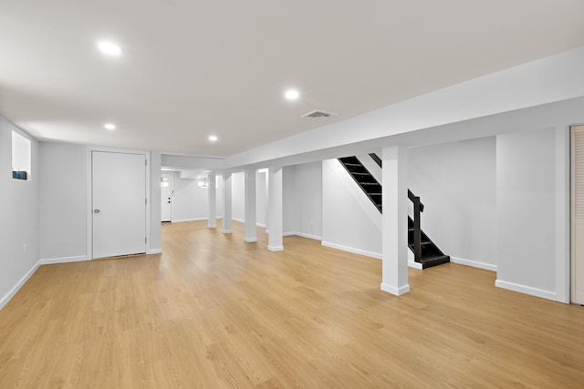 finished basement featuring stairs, light wood-style flooring, recessed lighting, and visible vents