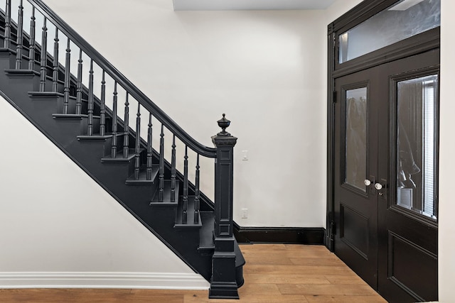 entrance foyer with stairway, wood finished floors, and baseboards