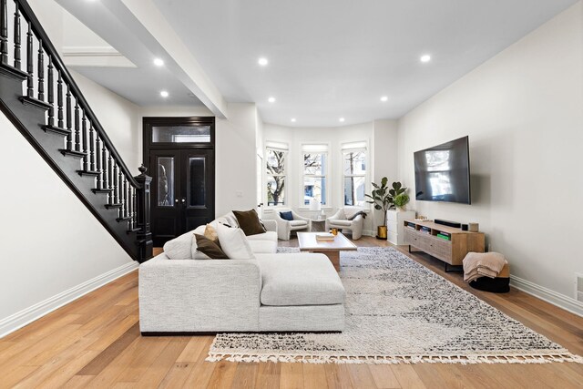 living area with stairway, recessed lighting, wood finished floors, and baseboards