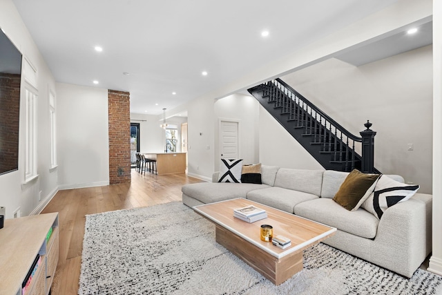 living area featuring stairway, recessed lighting, baseboards, and light wood finished floors