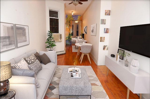 living room featuring baseboard heating, ceiling fan, crown molding, and light hardwood / wood-style floors