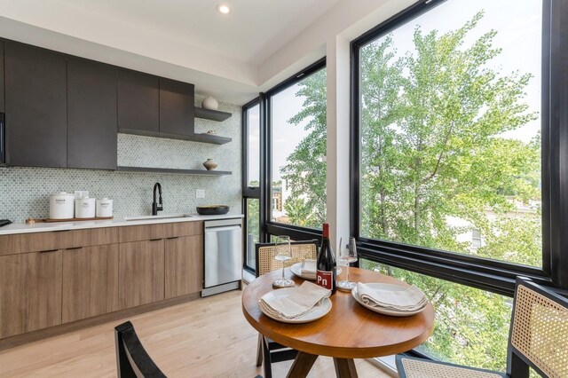 433 Central Ave Unit 3A, Jersey City, NJ 07307 - kitchen with stainless steel dishwasher, light countertops, light wood-style flooring, backsplash, and modern cabinets