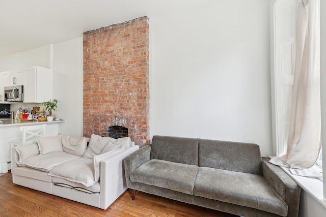 300 Barrow St, Jersey City, NJ 07302 - living area featuring baseboard heating, a fireplace, and light wood-type flooring