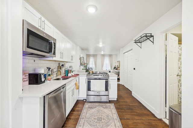 300 Barrow St, Jersey City, NJ 07302 - kitchen with a peninsula, stainless steel appliances, white cabinets, dark wood-style flooring, and light countertops