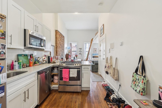 300 Barrow St, Jersey City, NJ 07302 - kitchen with a peninsula, light countertops, appliances with stainless steel finishes, decorative backsplash, and dark wood-style floors
