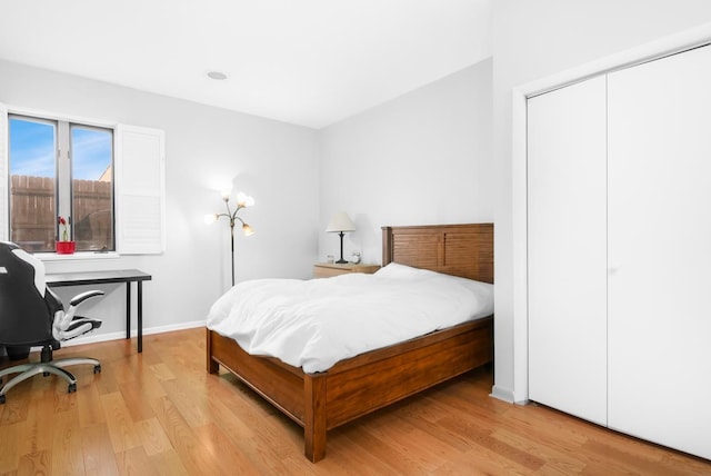 bedroom featuring a closet, baseboards, and wood finished floors