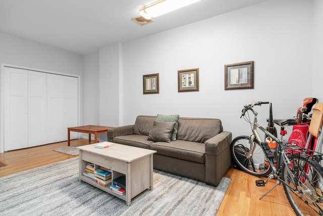 living area with visible vents and wood finished floors