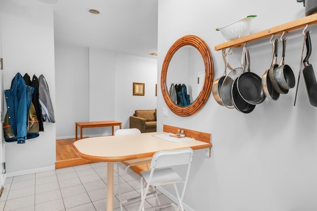 dining space with light tile patterned floors, visible vents, and baseboards