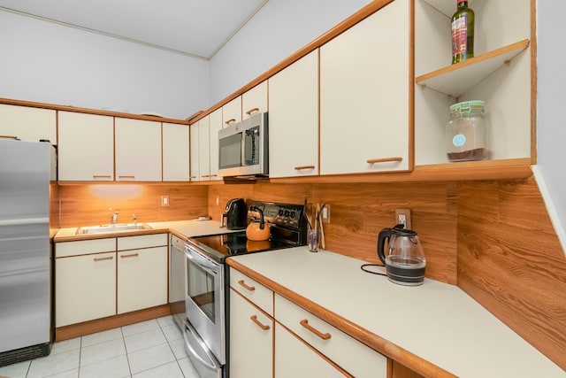 kitchen with a sink, light countertops, stainless steel appliances, white cabinetry, and open shelves