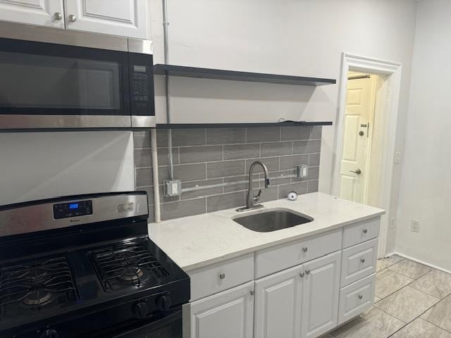 kitchen featuring white cabinetry, sink, tasteful backsplash, and gas stove