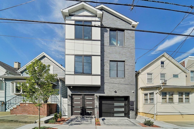 313 Lembeck Ave Unit 1, Jersey City, NJ 07305 - contemporary house featuring brick siding, concrete driveway, and an attached garage
