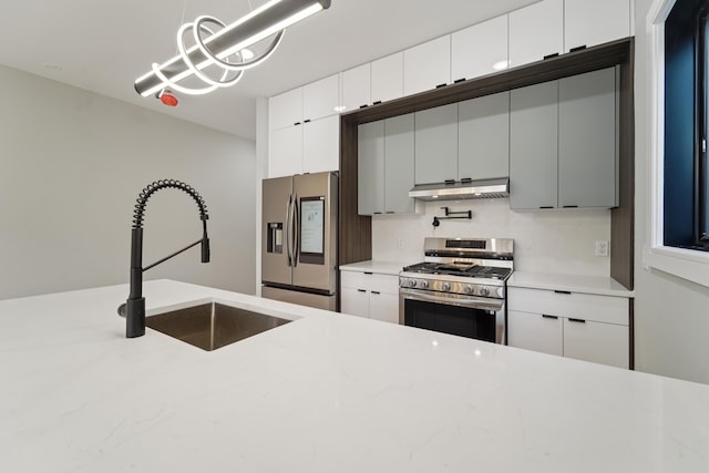 313 Lembeck Ave Unit 1, Jersey City, NJ 07305 - kitchen featuring appliances with stainless steel finishes, under cabinet range hood, white cabinetry, and hanging light fixtures