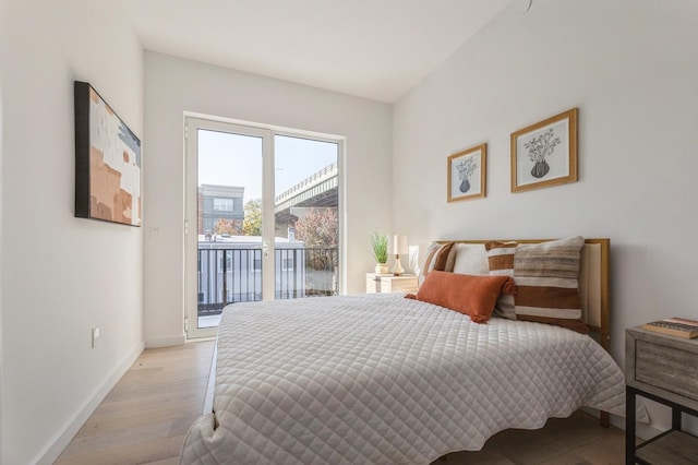 bedroom featuring light wood-type flooring, baseboards, and access to exterior