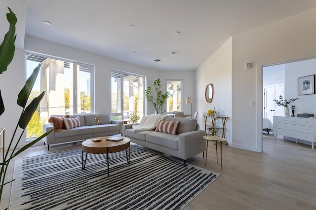 living area featuring baseboards and light wood-style flooring