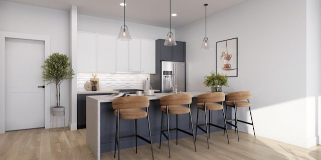kitchen featuring light wood-style floors, light countertops, a kitchen breakfast bar, backsplash, and stainless steel refrigerator with ice dispenser
