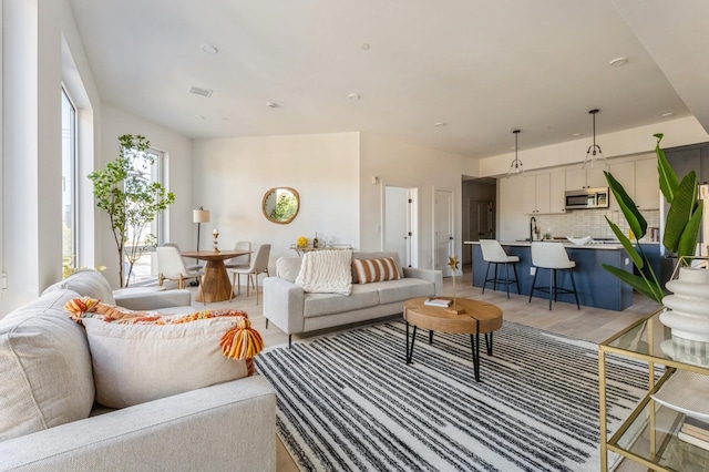 living area with light wood-style flooring and visible vents