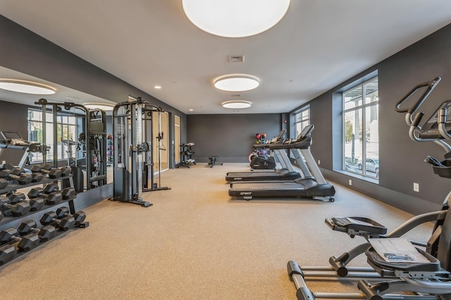 exercise room with baseboards, carpet floors, and visible vents