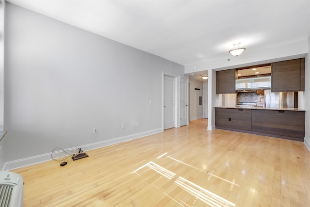 unfurnished living room with baseboards and light wood-style flooring