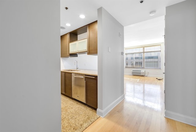 kitchen with light wood-type flooring, a sink, recessed lighting, baseboards, and dishwasher