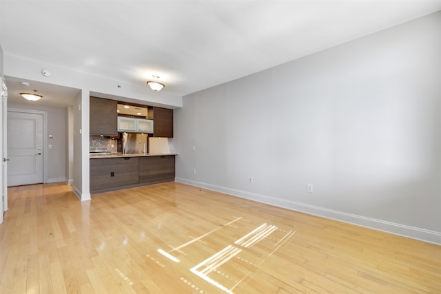 unfurnished living room with baseboards and light wood finished floors