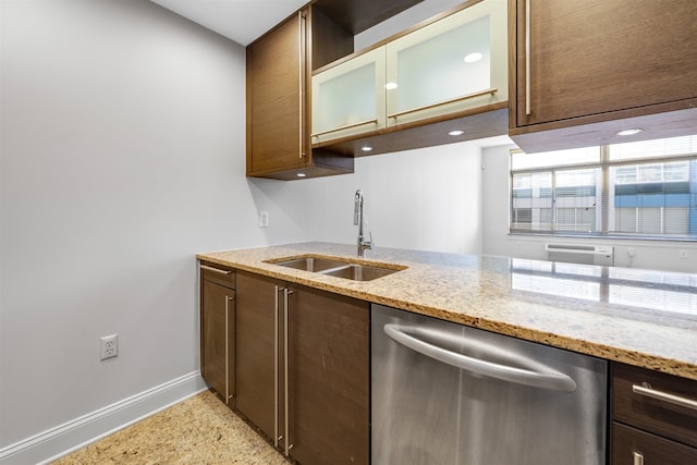 kitchen featuring a sink, baseboards, dishwasher, and light stone countertops