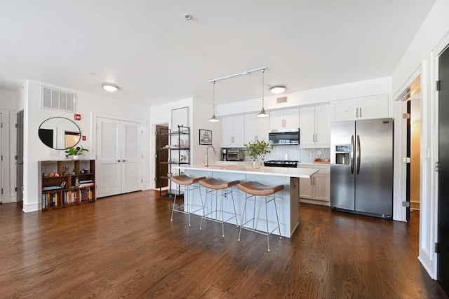 123 Jackson St Unit 4A, Hoboken, NJ 07030 - kitchen featuring appliances with stainless steel finishes, light countertops, a breakfast bar, backsplash, and dark wood-style flooring