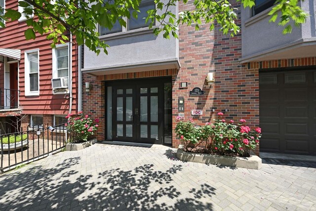 123 Jackson St Unit 4A, Hoboken, NJ 07030 - doorway to property with french doors, brick siding, cooling unit, and a garage