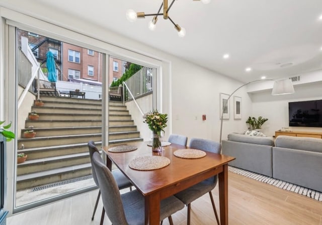 243 3rd St Unit 1, Jersey City, NJ 07302 - dining space with stairway, light wood-style flooring, recessed lighting, and a chandelier